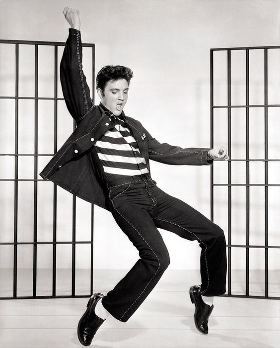 Elvis Presley doing dance moves on the stage.