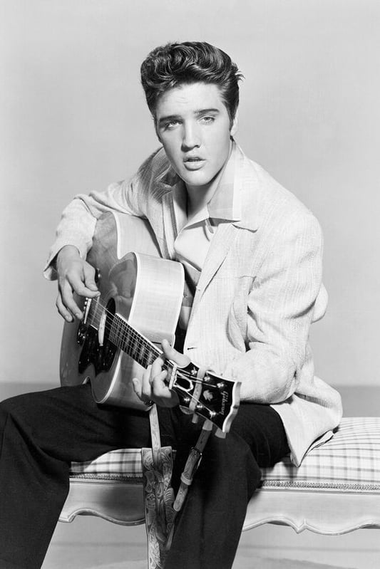Elvis Presley playing a guitar.